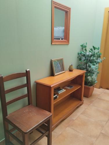 a wooden cabinet with a mirror and a chair at Albergue Kortarixar in Elizondo