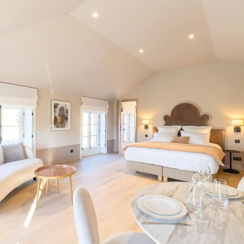 - une grande chambre avec un lit et une table dans l'établissement Les Suites BB, Champagne Besserat de Bellefon, à Épernay