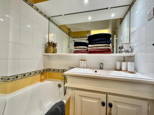 un bagno con vasca, lavandino e specchio di Les Restanques 1030 Arum rez de jardin a Grimaud