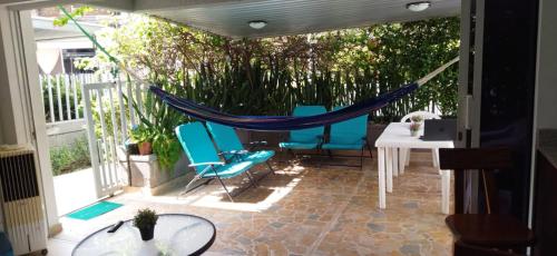 a patio with a hammock and a table and chairs at Hermoso Apartasol!! cerca a Plaza Principal, Aire Acondicionado, Vista a la Piscina in Santa Fe de Antioquia