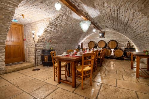 - une salle à manger avec une table et un bouquet de barils de vin dans l'établissement Hôtel De La Beursaudiere, à Nitry