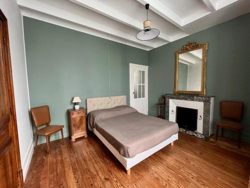 - une chambre avec un lit, un miroir et une cheminée dans l'établissement Maison familiale Les Boucs, à Rouffignac
