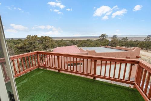 a balcony with green grass and a view at Crestone Adobe Vista Manor in Crestone
