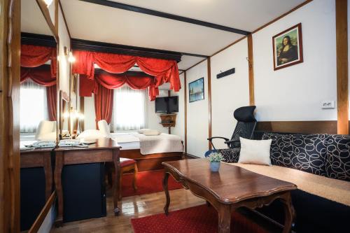 a living room with a couch and a bed at Hotel Garten in Slavonski Brod