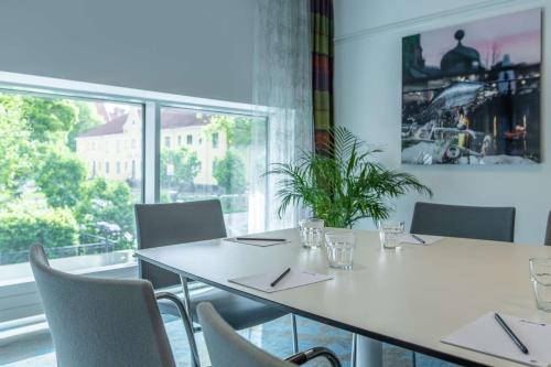 a meeting room with tables and chairs and a large window at Radisson Blu Hotel Uppsala in Uppsala
