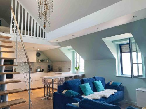 un salon avec un canapé bleu et une cuisine dans l'établissement Amazing sea view modern apartment Port de la Houle, à Cancale