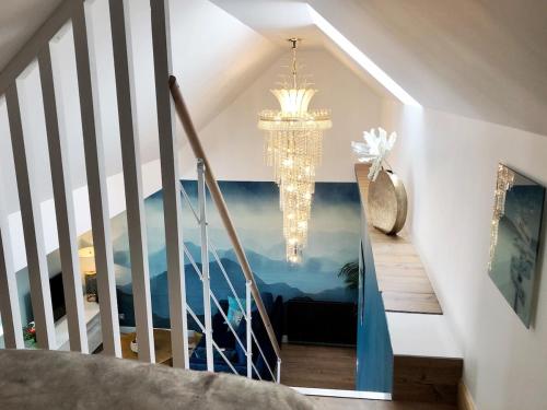 - un escalier avec un lustre dans une maison dans l'établissement Amazing sea view modern apartment Port de la Houle, à Cancale