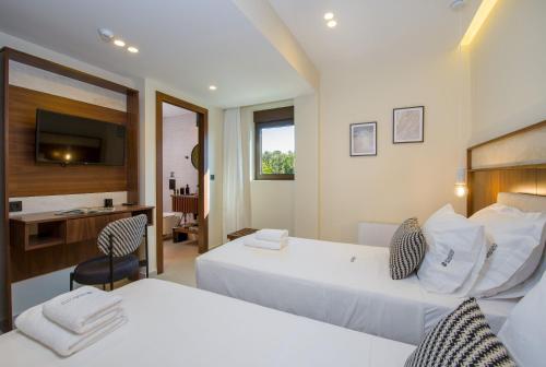 a hotel room with two beds and a desk at Almi-Cove Hilltop Villas in Almirida