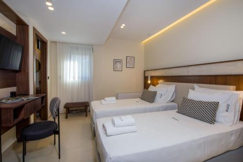 a hotel room with two beds and a desk at Almi-Cove Hilltop Villas in Almirida