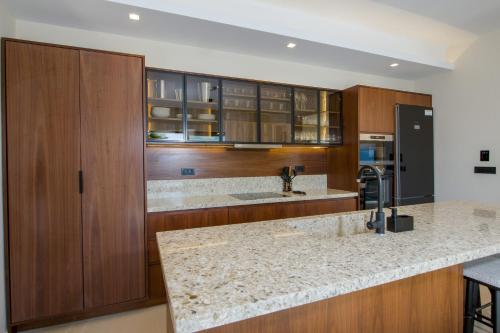 a kitchen with wooden cabinets and a granite counter top at Almi-Cove Hilltop Villas in Almirida