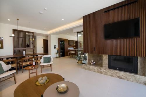 a living room with a fireplace and a tv at Almi-Cove Hilltop Villas in Almirida