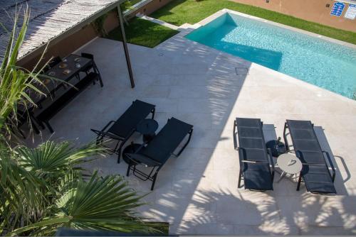 an overhead view of a patio with chairs and a pool at Almi-Cove Hilltop Villas in Almirida