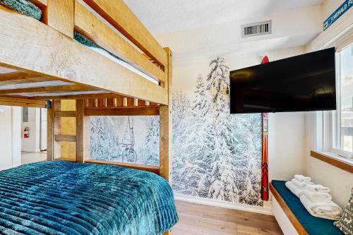 Un dormitorio con una cama y un televisor de pantalla plana. en Okemo Mountain Lodge A208, en Ludlow