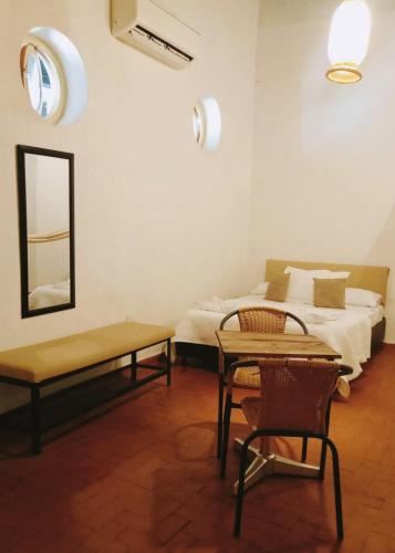 a bedroom with a bed and a table and a mirror at Lotus Central Hotel in Santa Marta