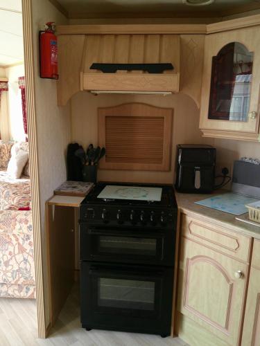 a kitchen with a stove in a tiny caravan at Golden Sands Willerby GS 6 Berth Panel heated FREE WIFI in Ingoldmells
