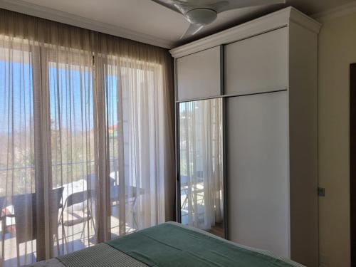 a bedroom with a bed and a large window at Guest House Botanical Paradise in Mtsvane Kontskhi