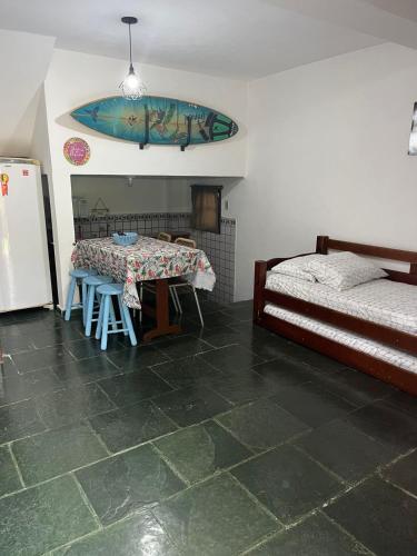 a room with a table and a bed and a refrigerator at Chales da Lua Juquehy in Juquei