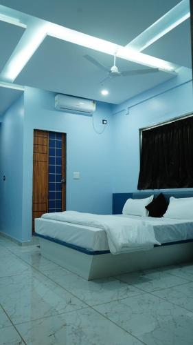 a bedroom with a bed in a blue room at Hotel Kailash Inn in Garudeshwar