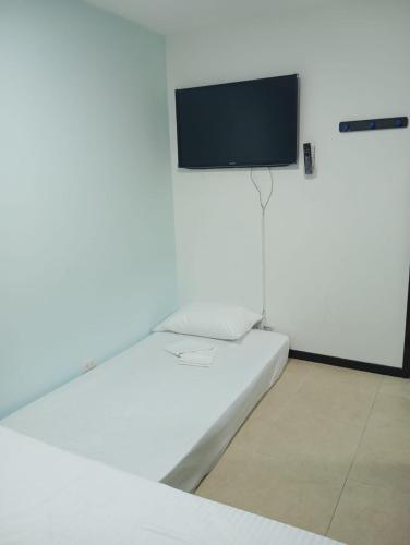 a white room with a flat screen tv on a wall at Hermoso Apartasol!! cerca a Plaza Principal, Aire Acondicionado, Vista a la Piscina in Santa Fe de Antioquia