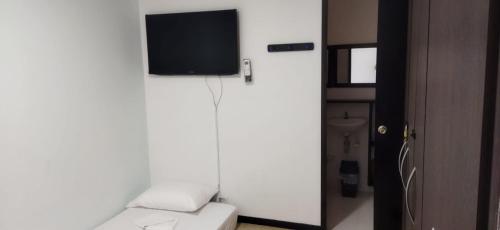 a room with a tv on a white wall at Hermoso Apartasol!! cerca a Plaza Principal, Aire Acondicionado, Vista a la Piscina in Santa Fe de Antioquia