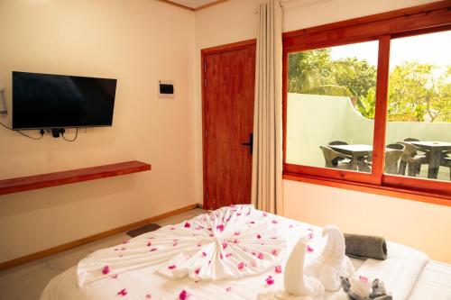 a bedroom with a bed with a tv and a window at Ari Paradise in Hangnaameedhoo