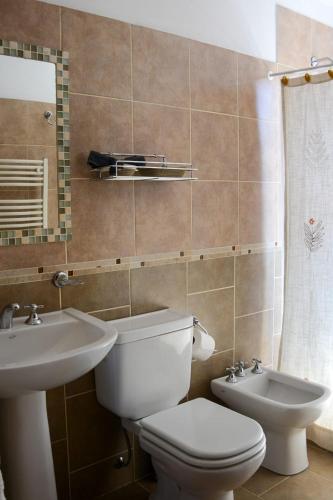 a bathroom with a toilet and a sink at Casa Almendro-Chumamaya-Villa de Merlo in Country Club Chumamaya