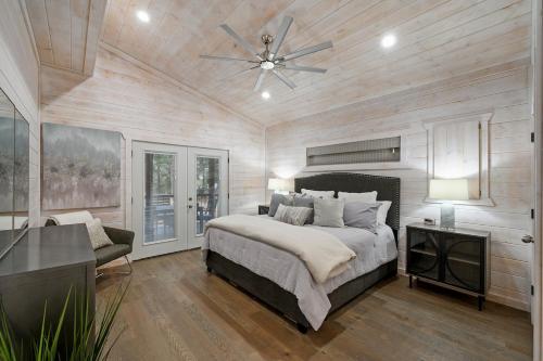 une chambre avec un lit et un ventilateur de plafond dans l'établissement The Modern Luxurious Mystic Love Cabin, à Broken Bow