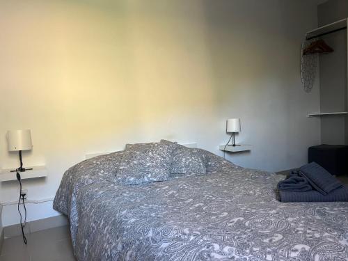 a bed in a bedroom with two lamps on the wall at Lost Paradise in San Andrés