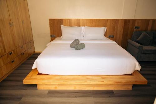 a bed with a stuffed animal sitting on top of it at Ari Paradise in Hangnaameedhoo