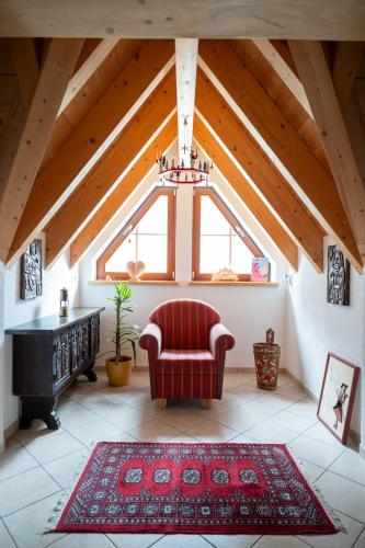 a living room with a red chair and a window at Ferienanlage Zum Silberstollen 2 Häuser am Berg Polderhof und Weißeritzhütte in Kurort Altenberg