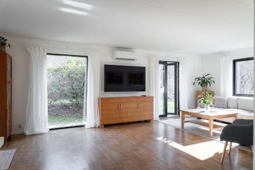 a living room with a couch and a tv at Grevie skogsvilla in Grevie