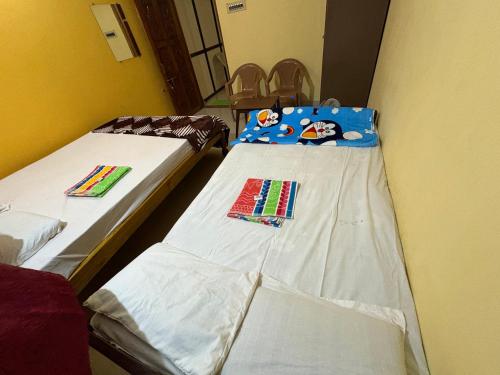 a room with two beds in a room at Kanasu guest house in Gokarna