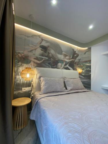 a bedroom with a bed with a painting on the wall at Ionian View B&B in Himare