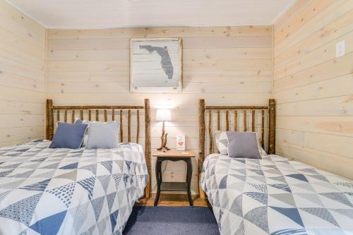 two beds in a room with wooden walls at North Carolina Cabin - Pool Table and Mountain Views in Murphy