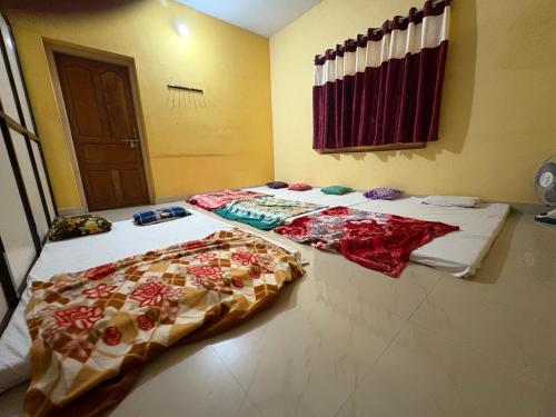two beds sitting on the floor in a room at Kanasu guest house in Gokarna