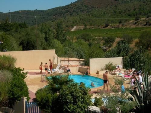 un groupe de personnes debout autour d'une piscine dans l'établissement Les chalets du Relais d'Aguilar, à Tuchan