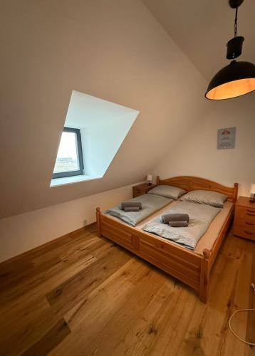 a bedroom with a wooden bed and a window at Balaton Lake House in Balatonudvari