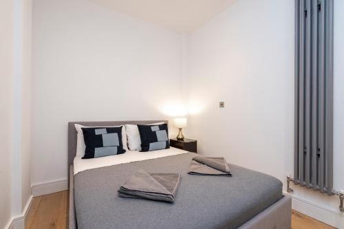 a bedroom with a bed with two towels on it at Covent Garden Residence in London