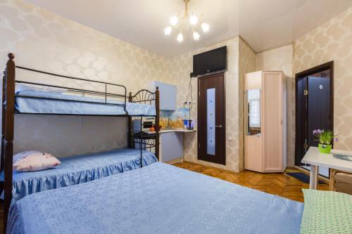 1 dormitorio con 2 literas y escritorio en Adoriya Apartments, en San Petersburgo