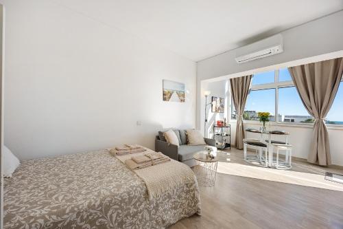 a white bedroom with a bed and a couch at Casa da Torralta in Alvor