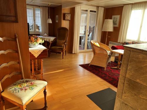 a living room with a table and chairs and a kitchen at Engel Ingold Lodge Chalet "Böhli" in Ringgenberg