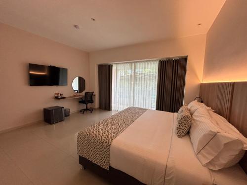 a hotel room with a bed and a window at Casa Aurora Luxury Hotel in Cali