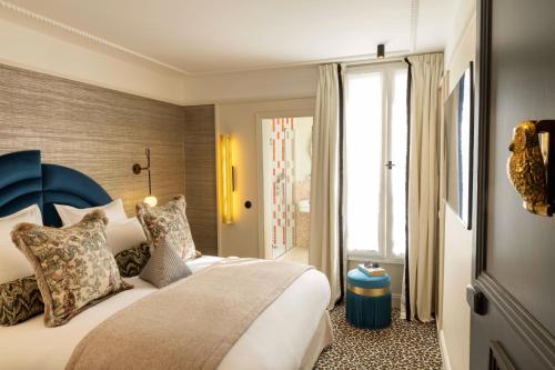 a bedroom with a large bed with a blue headboard at Hôtel l'Inattendu in Paris