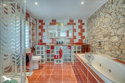 un bagno con vasca, WC e lavandino di Chambres d'Hôtes L'Hermitage ad Anzex