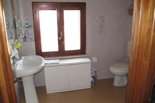 baño con lavabo y aseo y ventana en Il Balcone Holiday House, en Parma