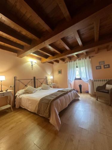 a bedroom with a large bed in a room with wooden floors at Casa Rural Anxeliña in Boborás