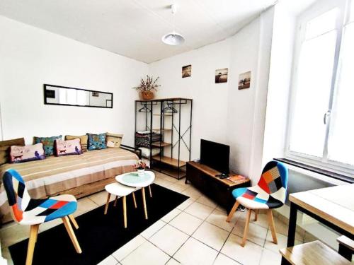 - un salon avec un lit et deux chaises dans l'établissement T2 Duplex avec Terrasse vue Cathédrale, à Narbonne