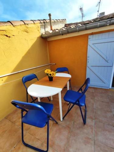 - une table et quatre chaises sur une terrasse avec une porte dans l'établissement T2 Duplex avec Terrasse vue Cathédrale, à Narbonne