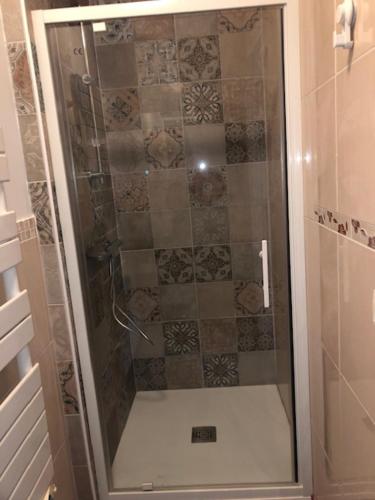 une douche avec une porte vitrée dans une salle de bain dans l'établissement appartement spacieux avec piscine à 15 minutes d'Hossegor, à Saint-Vincent-de-Tyrosse