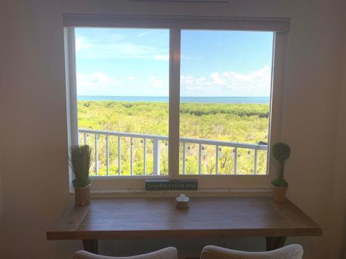 a window with a table and a view of the ocean at Ocean Pointe Resorts - Serenity 2308 in Tavernier